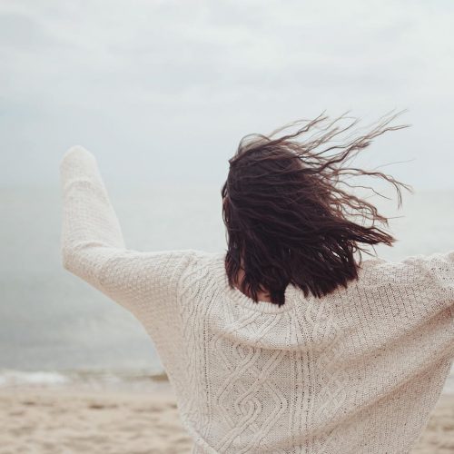carefree-woman-in-sweater-with-windy-hair-running--5TWVG59